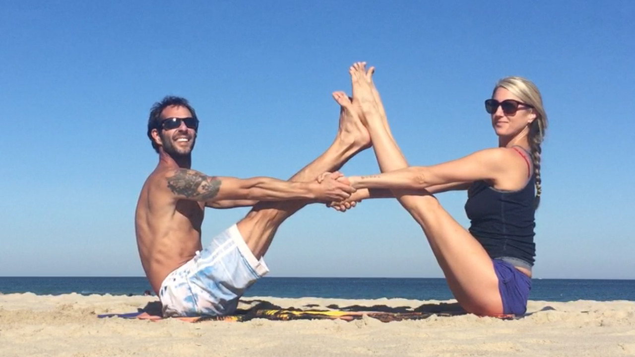 Couple-practicing-yoga-on-the-beach